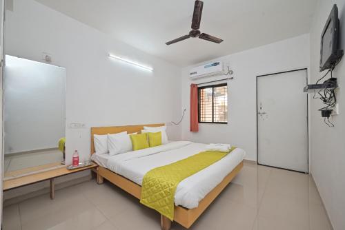 a bedroom with a bed and a flat screen tv at Jalsa Villas in Saputara