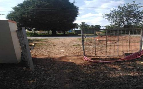 a gate in a dirt field with a fence at Mango Ville in Bangalore