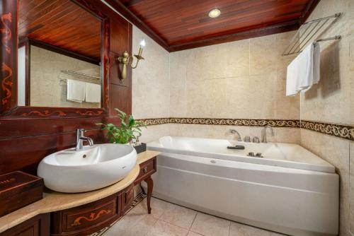 a bathroom with a white tub and a sink at Indochina Sails Ha Long Bay Powered by ASTON in Ha Long