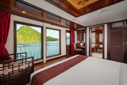a bedroom with a bed with a view of a mountain at Indochina Sails Ha Long Bay Powered by ASTON in Ha Long