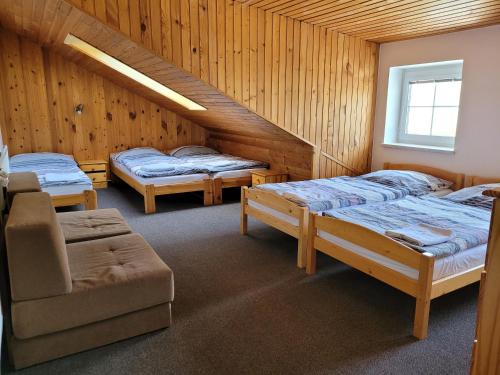 a room with three beds and a chair in it at Chalupa Chiranka in Lipova Lazne