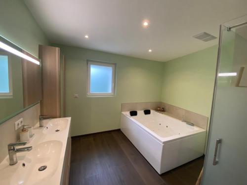 uma casa de banho com 2 lavatórios e uma banheira em Grange rénovée esprit loft Côte d'Opale em Wierre-Effroy