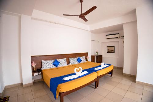 een slaapkamer met een bed met een blauwe en gele sprei bij VKG Hotels in Pondicherry