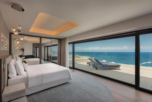 The Westin Dragonara Resort, Malta في سانت جوليانز: غرفة نوم مع سرير وإطلالة على المحيط