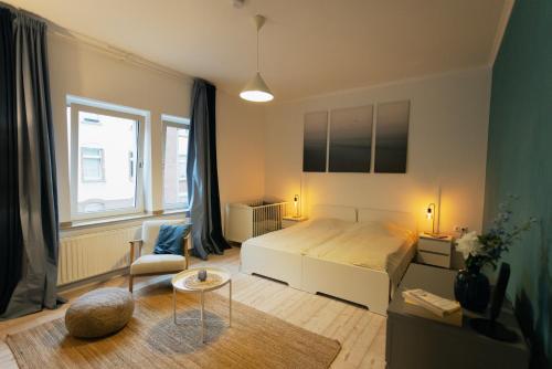 a bedroom with a bed and a chair and a table at Huge apartment with Sauna and free parking in Duisburg