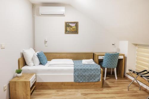 a bedroom with a bed and a desk with a chair at Grand Park rooms & apartments in Čačak