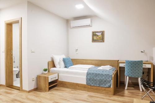 a bedroom with a bed and a desk and a mirror at Grand Park rooms & apartments in Čačak