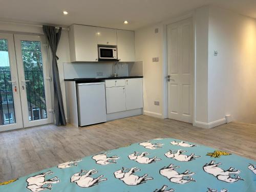 a living room with a kitchen with pigs on a rug at Lovely Self Contained Loft Studio - 33AS4 in London