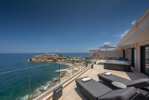 a balcony with chairs and a view of the ocean at The Westin Dragonara Resort, Malta in St. Julianʼs