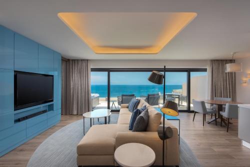 a living room with a couch and a television at The Westin Dragonara Resort, Malta in St. Julianʼs