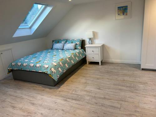 um quarto com uma cama, uma mesa de cabeceira e uma janela em Lovely Self Contained Loft Studio - 33AS4 em Londres