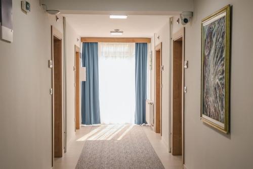 a hallway with a large window and a rug at Grand Park rooms & apartments in Čačak