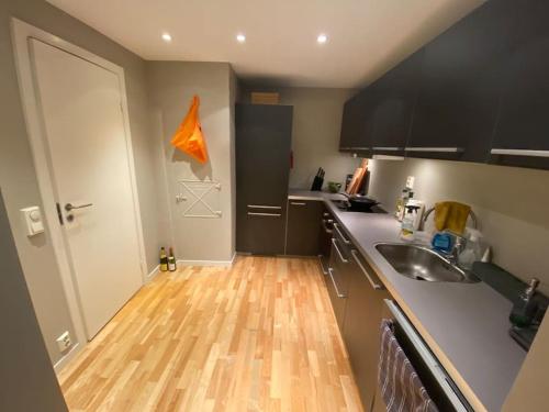 a kitchen with a wooden floor and a sink at Koslig leilighet i Bergens smørøye in Bergen