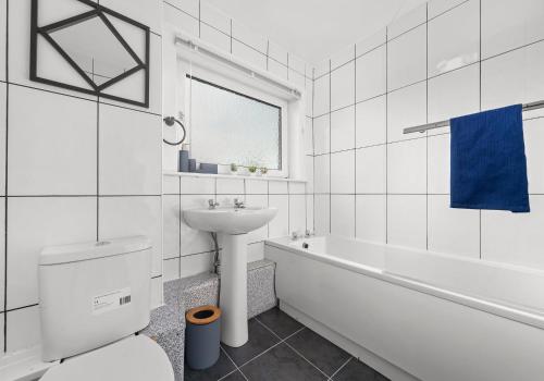 a white bathroom with a sink and a toilet and a tub at Berwick Apartment by Klass Living Coatbridge in Coatbridge