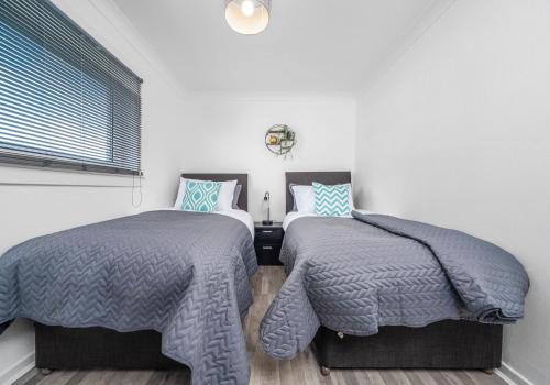 two beds sitting next to each other in a bedroom at Berwick Apartment by Klass Living Coatbridge in Coatbridge