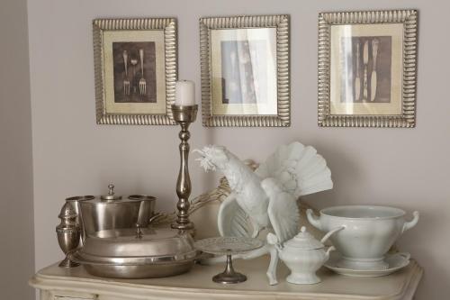 a table with a tray with a bird statue and some pictures at Pastel Guesthouse in Balatonfüred