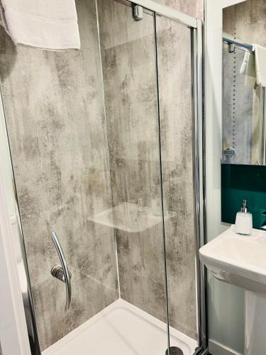 a shower with a glass door in a bathroom at Killorn Guest House in Oban