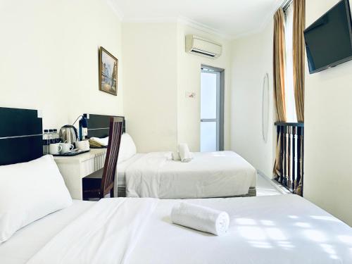 ein Hotelzimmer mit 2 Betten und einem TV in der Unterkunft Asphodel Inn in Singapur