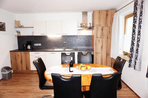 a kitchen and dining room with a table and chairs at Ferienwohnung Aignerhof in Schellgaden