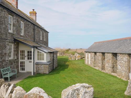 an exterior view of a stone house with a yard at Three Chimneys in Penzance