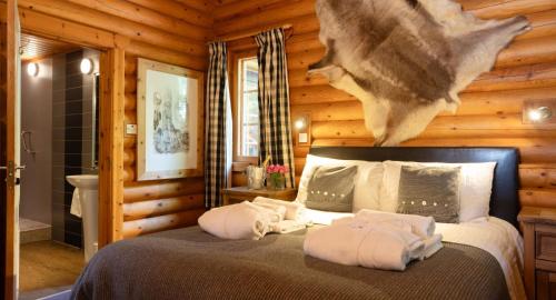 a bedroom with a bed in a log cabin at Beaver Creek Lodge in Aviemore