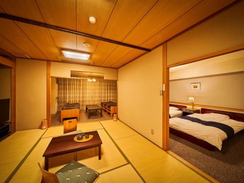 een hotelkamer met een bed en een tafel bij Yukai Resort Dogo Saichoraku in Matsuyama