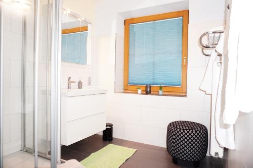 a white bathroom with a sink and a window at Ferienwohnung Aignerhof in Schellgaden