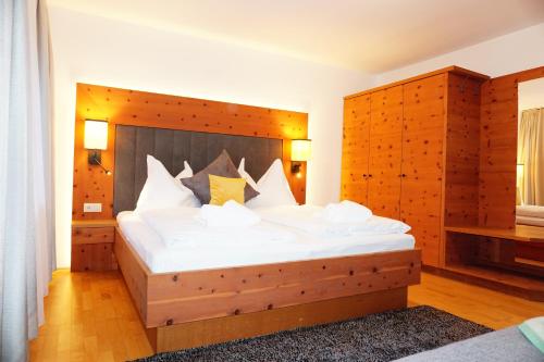 a bedroom with a large bed with a wooden headboard at Ferienwohnung Aignerhof in Schellgaden
