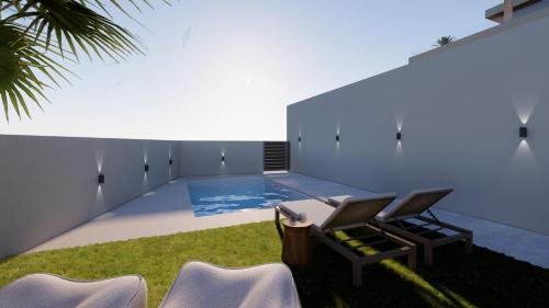 a room with a swimming pool with chairs in the grass at Searenity Villa Malia with private swimming pool in Malia