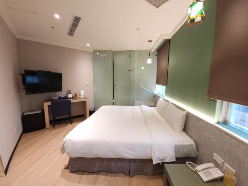 a bedroom with a large white bed and a desk at Merryday Hotel Banqiao in Taipei