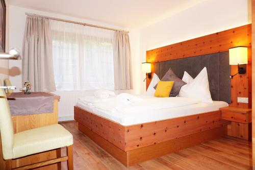 Schlafzimmer mit einem großen Bett mit einem Kopfteil aus Holz in der Unterkunft Ferienwohnung Aignerhof in Schellgaden