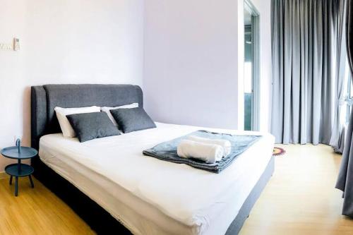 - une chambre avec un lit doté de draps blancs et d'oreillers gris dans l'établissement Near SunwayPyramid 2Bed2Bathroom, à Subang Jaya