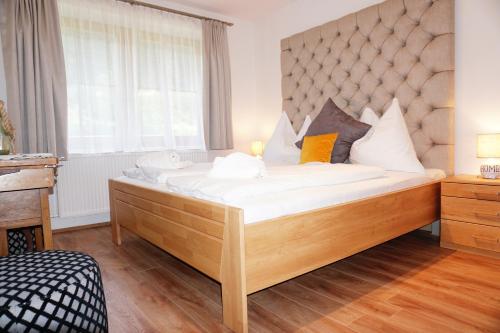a large bed in a room with a large window at Ferienwohnung Aignerhof in Schellgaden