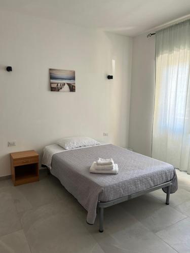 Un dormitorio con una cama con una toalla encima. en Piccola Flo rooms, en Cagliari