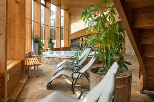 a group of chairs and a pool in a building at AlpenParks Hotel & Apartment Carpe Solem Mariapfarr in Mariapfarr
