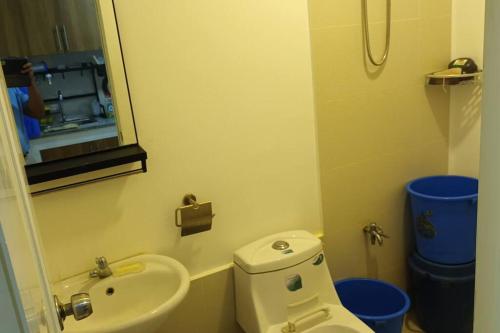a bathroom with a toilet and a sink and a mirror at Apartment Unit in Downtown Manila in Manila
