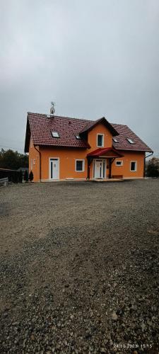 a large orange house on a dirt field at Penzion Forest 2 in Rozvadov