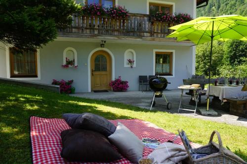a picnic blanket on the grass in front of a house at Ferienwohnung Aignerhof in Schellgaden