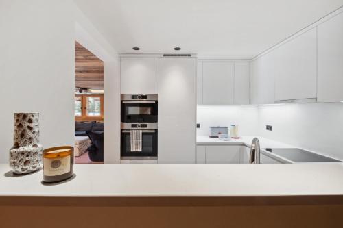 a kitchen with white cabinets and a counter top at Chalet Larchwood by Mrs Miggins in Grimentz