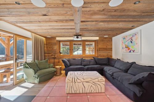 a living room with a couch and a table at Chalet Larchwood by Mrs Miggins in Grimentz
