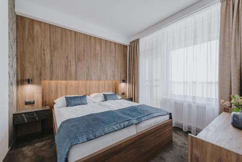 a bedroom with a bed and a large window at Hotel Glamour in Kaluža