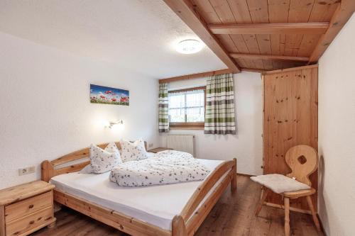 レンゲンフェルトにあるHauseggerhofのベッドルーム(木製ベッド1台、椅子付)