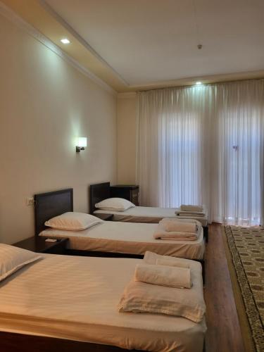 pokój z 3 łóżkami i oknem w obiekcie Dili Orom Hotel w mieście Buchara
