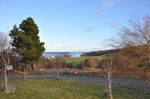 a view of a road with the ocean in the background at Strathview Lodge in Dornoch