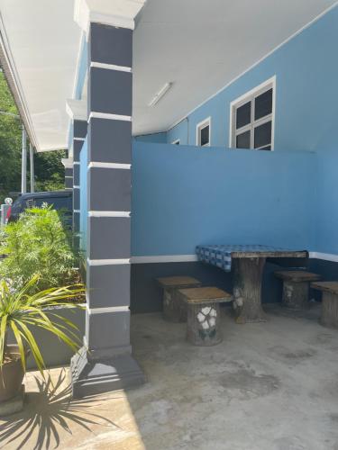 un edificio azul con mesa y bancos en D'PAYA HOMESTAY, en Bachok