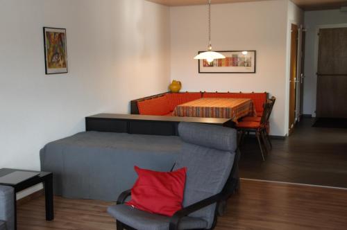 uma sala de estar com uma cama, uma mesa e cadeiras em Salve 9 em Leukerbad