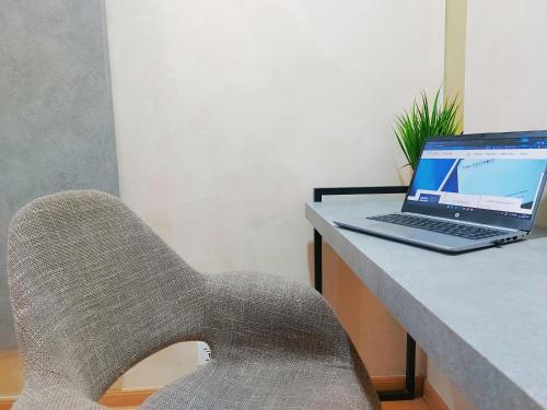 a chair sitting next to a desk with a laptop computer at The Leverage Business Hotel - Bandar Baru Mergong in Alor Setar