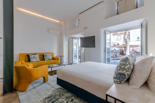 a bedroom with a bed and a couch and a chair at Portas do Céu in Lisbon