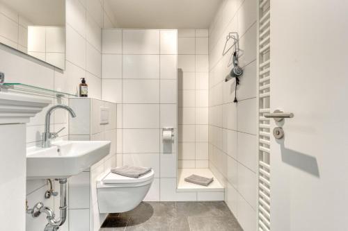 bagno bianco con lavandino e servizi igienici di Urlaubsmanufaktur a Norderney