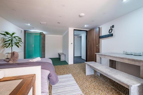 a bedroom with two beds and a table and a bench at Apar7mán Jizerské hory in Hejnice